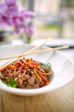 Beyaz plaka üzerinde sığır eti ve Chopsticks ile kızartma erişte soba, yakın çekim 