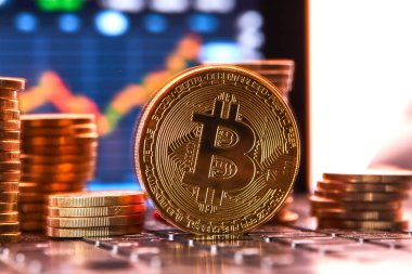 grafik arka plan üzerinde kripto para birimi için kavramsal görüntü ile klavye üzerinde altın bitcoins yığını