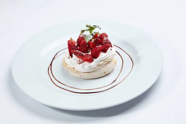 Strawberry pavlova cake on white plate, close-up