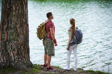 Güneşli gün göl kenarında duran iki gezginler 