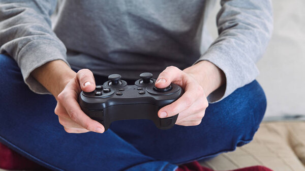 man holding joystick controllers while playing video games at home