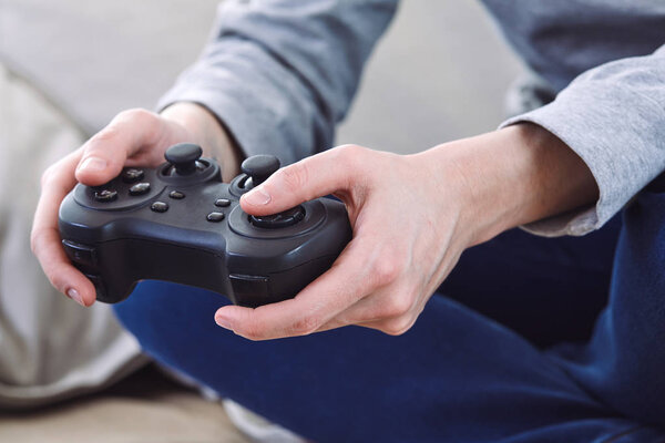 man holding joystick controllers while playing video games at home