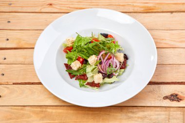 Vejetaryen salata kurutulmuş domates ve beyaz tabakta kruton yakın çekim 