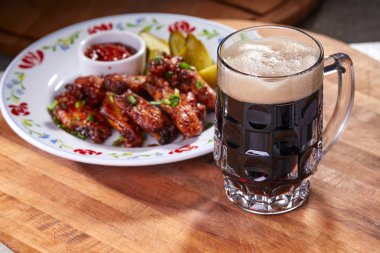 Ahşap kesme tahtasında meze ile servis edilen filtresiz bira pint, yakın çekim 