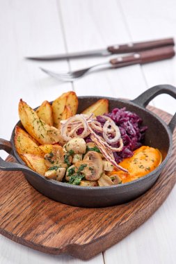 ahşap kesme tahtası üzerinde tavada tatlı patates ile kavrulmuş sebze , yakın çekim 