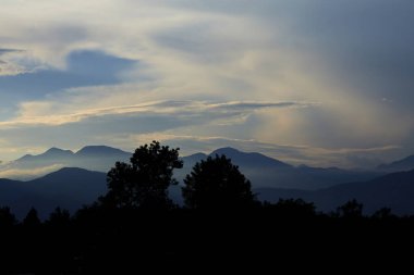 gün batımında arka planda gökyüzünde kabarık bulutlar ile dağların inanılmaz görünümü, Karadağ 