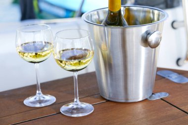 Beyaz şarap ve kova şişe yat ile çift kadehlerin