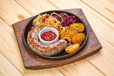 fırında patates ve salata ahşap arka plan üzerinde tavada ile sosis