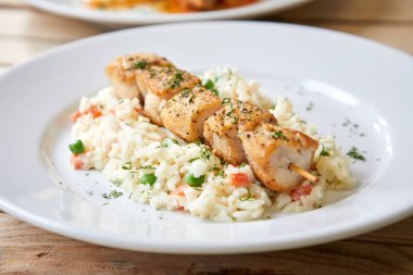 Beyaz plaka üzerinde pirinç ve sebze ile tavuk kebap, yakın çekim 