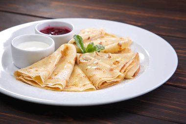 Krep ekşi krema ve beyaz tabakta berry sos ile yakın çekim 