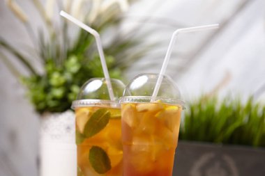 ahşap masada nane ve meyve ile plastik bardak yaz limonata, yakın çekim 