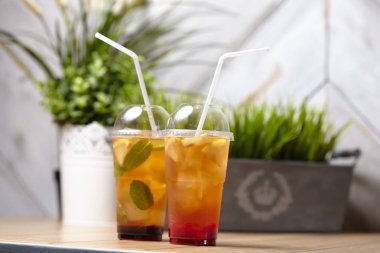 ahşap masada nane ve meyve ile plastik bardak yaz limonata, yakın çekim 