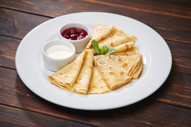 Krep ekşi krema ve beyaz tabakta berry sos ile yakın çekim 