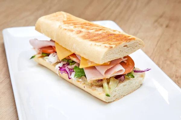 Sandwich Mit Schinken Und Gemüse Auf Weißem Teller Nahaufnahme — Stockfoto