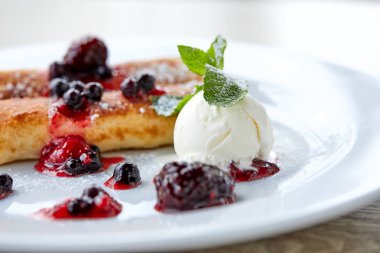 Beyaz plaka üzerinde çilek ve dondurma ile krep, yakın çekim 