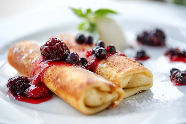 Beyaz plaka üzerinde çilek ve dondurma ile krep, yakın çekim 