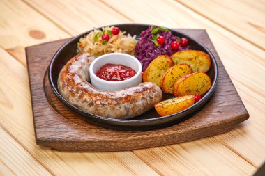ahşap arka planda salata ile sosis ve pişmiş patates ile Pan