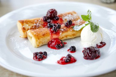 Beyaz plaka üzerinde çilek ve dondurma ile krep, yakın çekim 