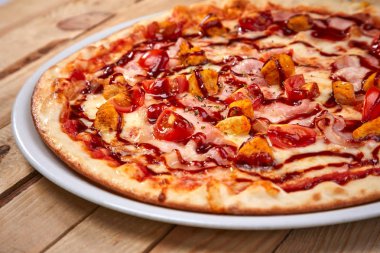 ahşap arka planda lezzetli İtalyan pizza ile beyaz tabak