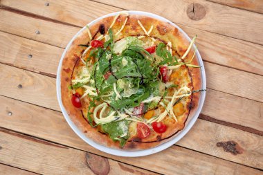 Tahta arka planda taze sebzeli pizza.