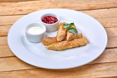 Krep ekşi krema ve beyaz tabakta berry sos ile yakın çekim 