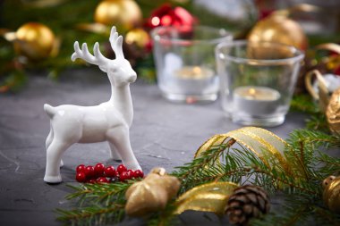 Christmas decoration with deer and colorful balls on grey background, close-up 