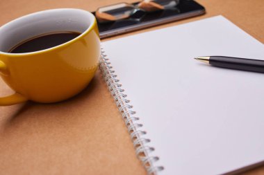 Ofis masaları, iş kavramı üzerinde not defteri ve kahve Kupası ile modern smartphone 