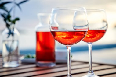 pasta üzerinde mavi suya karşı zeytin ile gül şarabı iki bardak