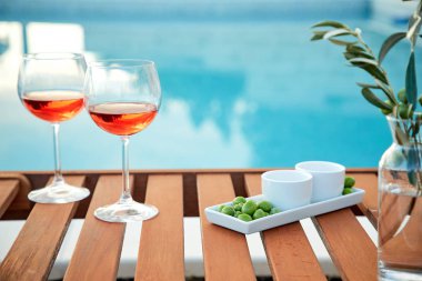 pasta üzerinde mavi suya karşı zeytin ile gül şarabı iki bardak