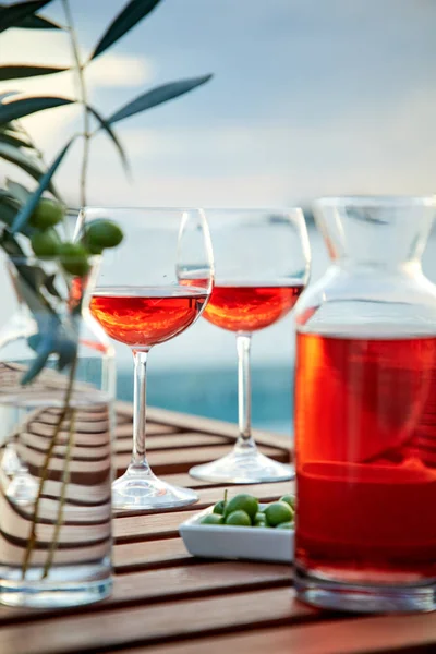 Dos Vasos Vino Rosas Con Aceitunas Contra Agua Azul Sobre —  Fotos de Stock