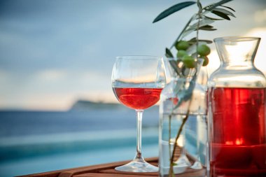 pasta üzerinde mavi suya karşı zeytin ile gül şarabı iki bardak