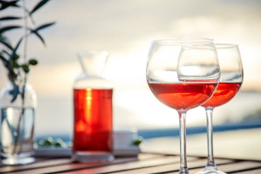 pasta üzerinde mavi suya karşı zeytin ile gül şarabı iki bardak