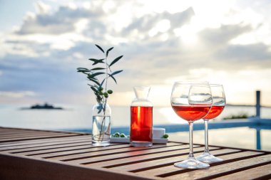 pasta üzerinde mavi suya karşı zeytin ile gül şarabı iki bardak