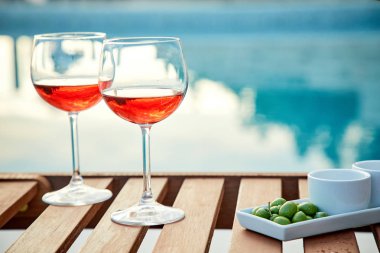 pasta üzerinde mavi suya karşı zeytin ile gül şarabı iki bardak