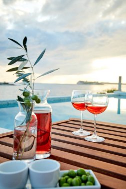 pasta üzerinde mavi suya karşı zeytin ile gül şarabı iki bardak