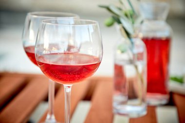 pasta üzerinde mavi suya karşı zeytin ile gül şarabı iki bardak