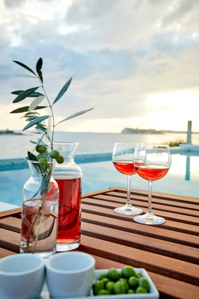 pasta üzerinde mavi suya karşı zeytin ile gül şarabı iki bardak