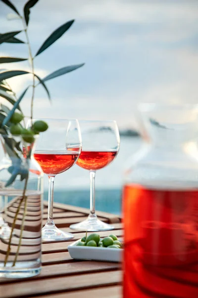 Dos Copas Vino Rosas Con Aceitunas Contra Agua Azul Muelle —  Fotos de Stock