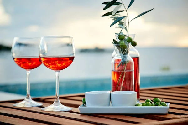 Dos Copas Vino Rosas Con Aceitunas Contra Agua Azul Muelle —  Fotos de Stock