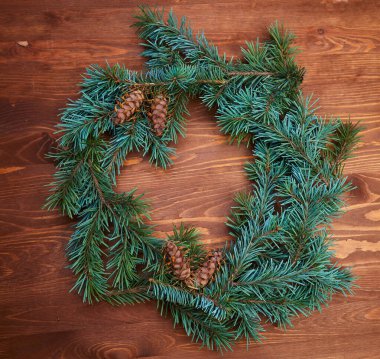 Ahşap arka planda konili Noel çelengi, yakın plan. 