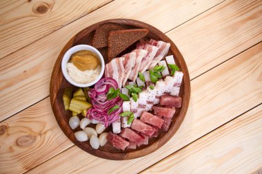 Ahşap arka planda et aperatifli tabak.