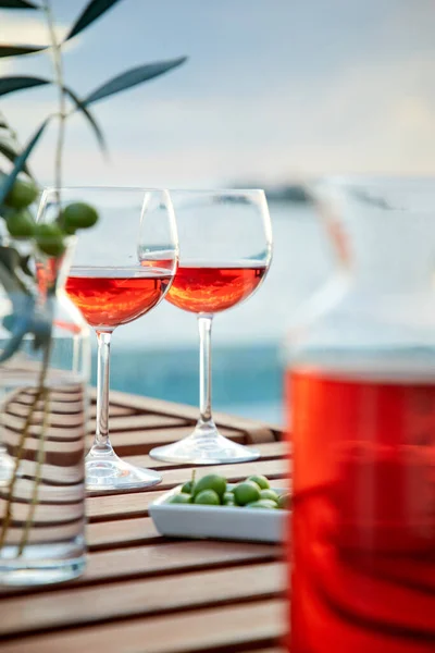 Due Bicchieri Vino Rosato Con Olive Contro Acqua Blu Sul — Foto Stock