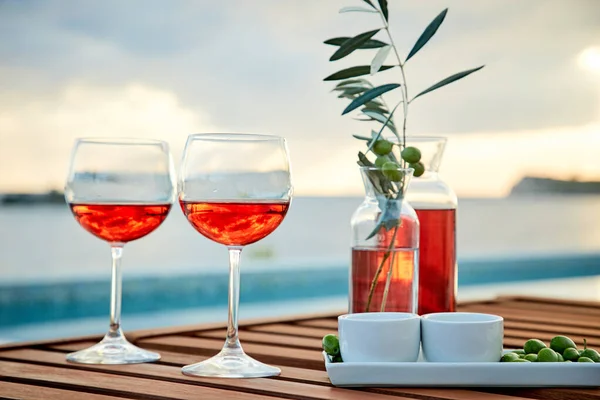 Due Bicchieri Vino Rosato Con Olive Contro Acqua Blu Sul — Foto Stock