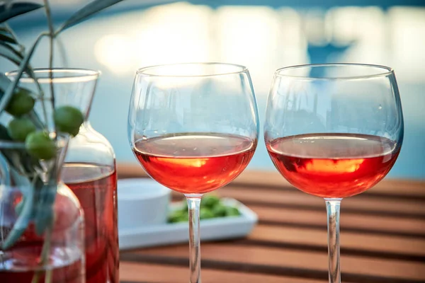 Dos Copas Vino Rosas Con Aceitunas Contra Agua Azul Muelle — Foto de Stock