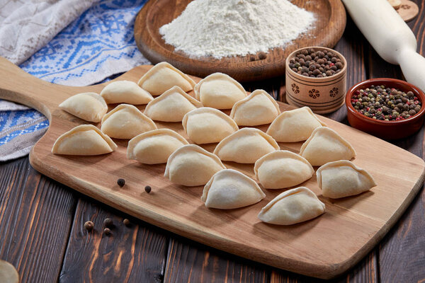 необработанные пельмени на деревянной доске, вид снизу 