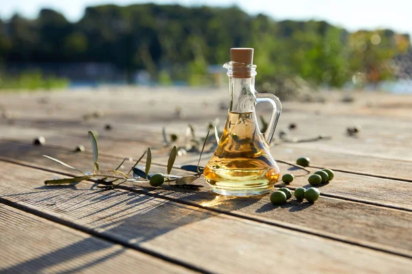 olive oil in bottle and branch of green olives, close view