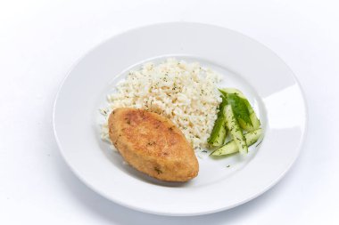 Pirinçli pirzola ve beyaz tabakta salatalık, yakın görüş. 