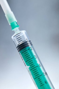 Gri arka planda uyuşturucu içeren tıbbi şırınga, yakın görüş  