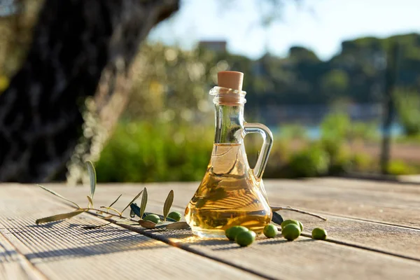 glass with olive oil and green olives outdoor