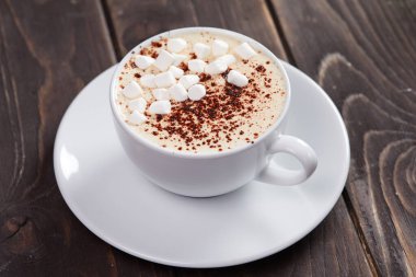 Kapuçino ve marşmelov. Ahşap arka planda.